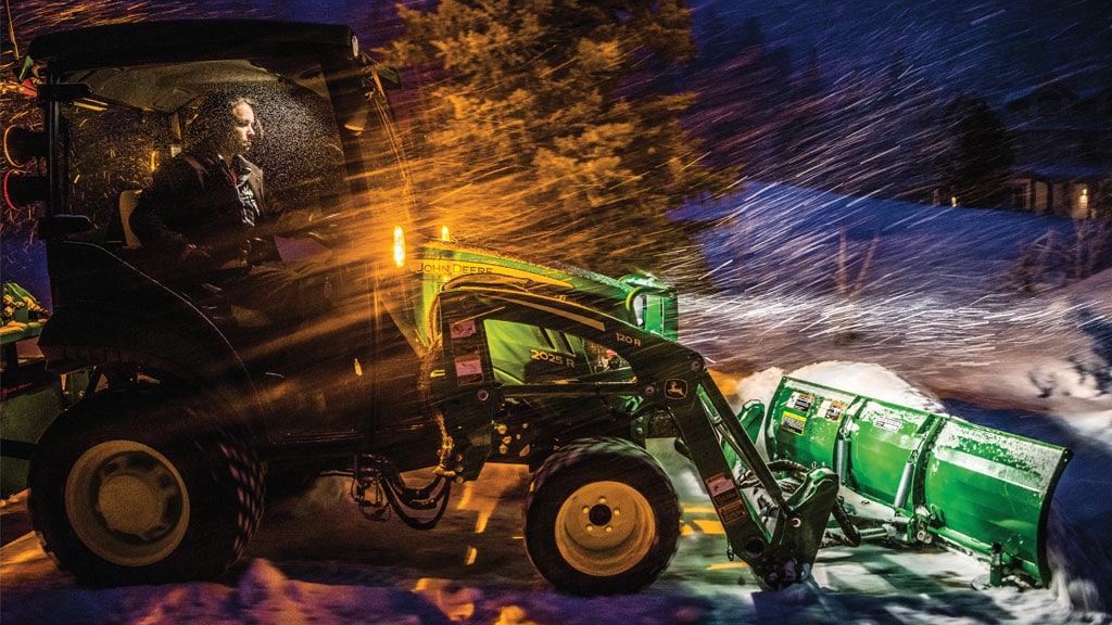John Deere 2025R plowing snow at night with AF10F front blade and Three point snow blower