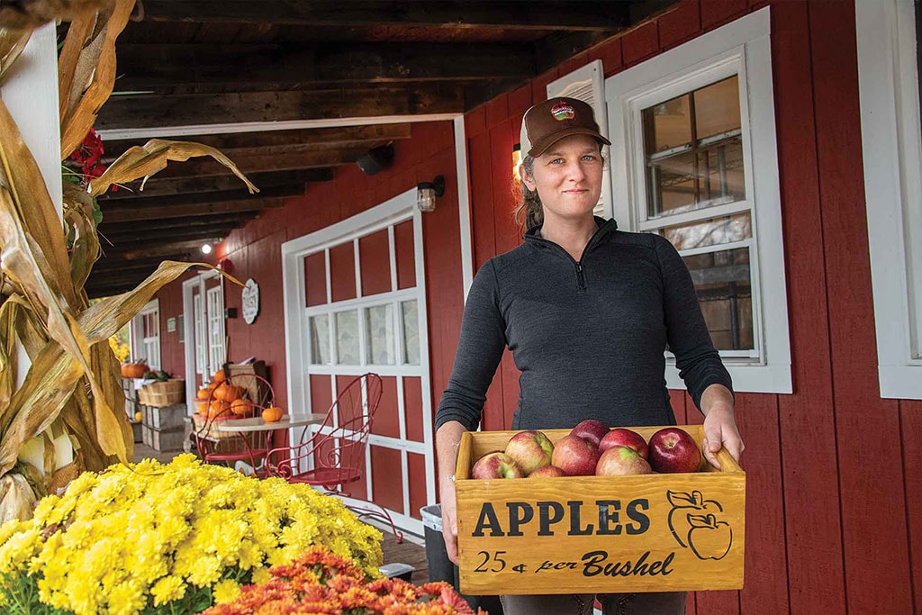 female holding box of apples