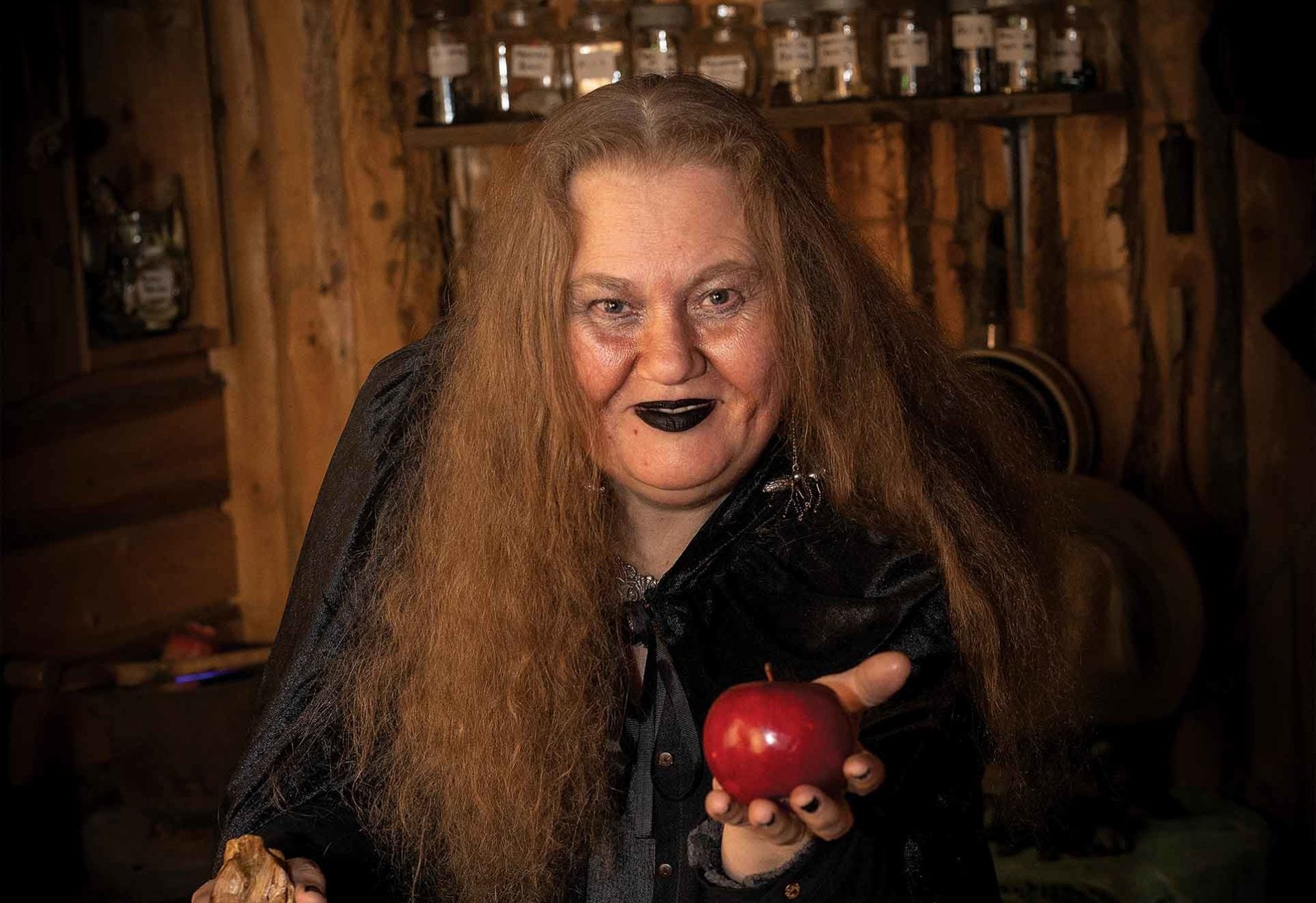 Women in haloween costume holding an apple