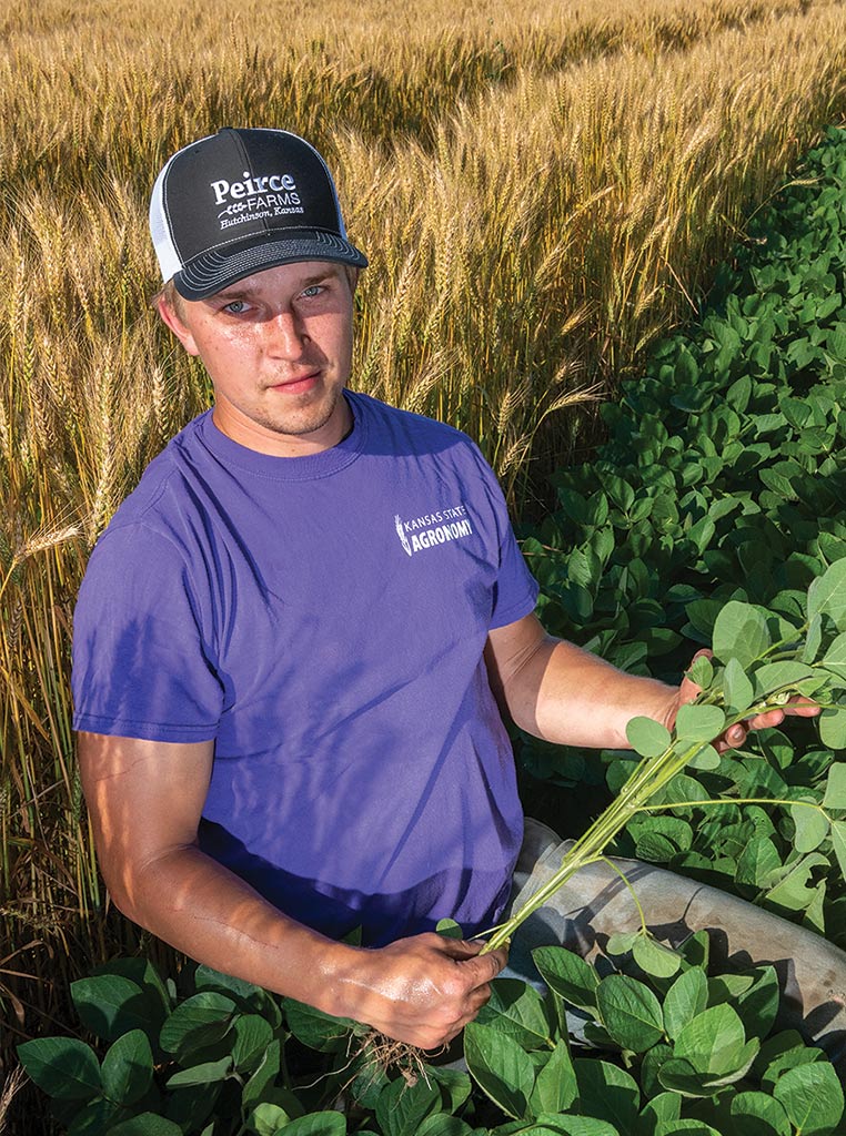 Connor Peirce holding a soybean plant