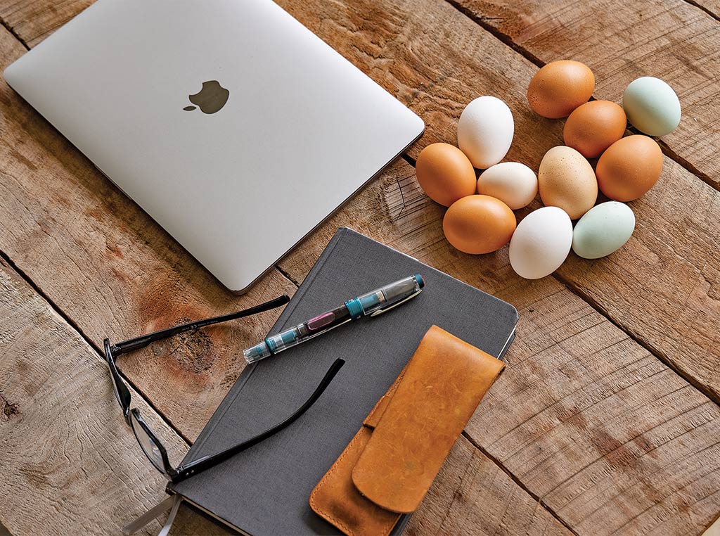 laptop, egggs, office items on a table