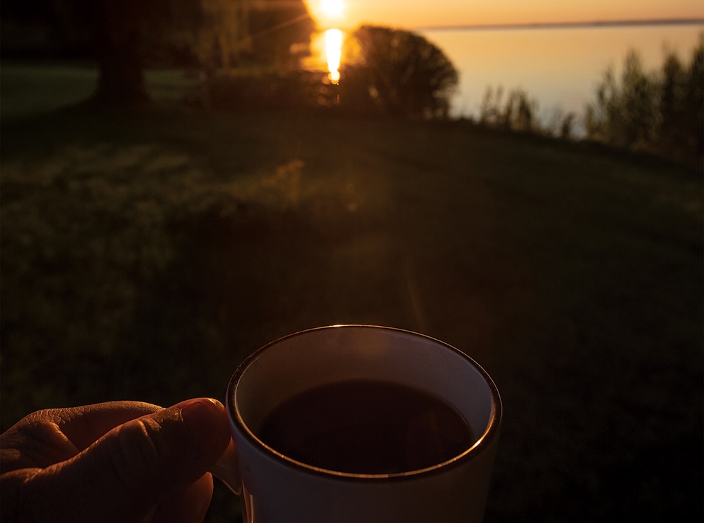 close up of coffee mug and view of lake in the background