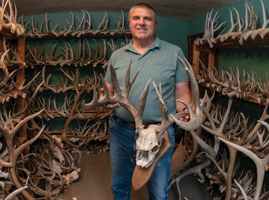 Man holding skull with antlers