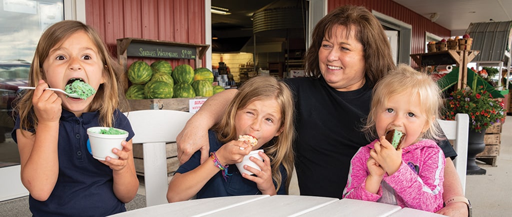 kids eating ice cream with family sitting with them.