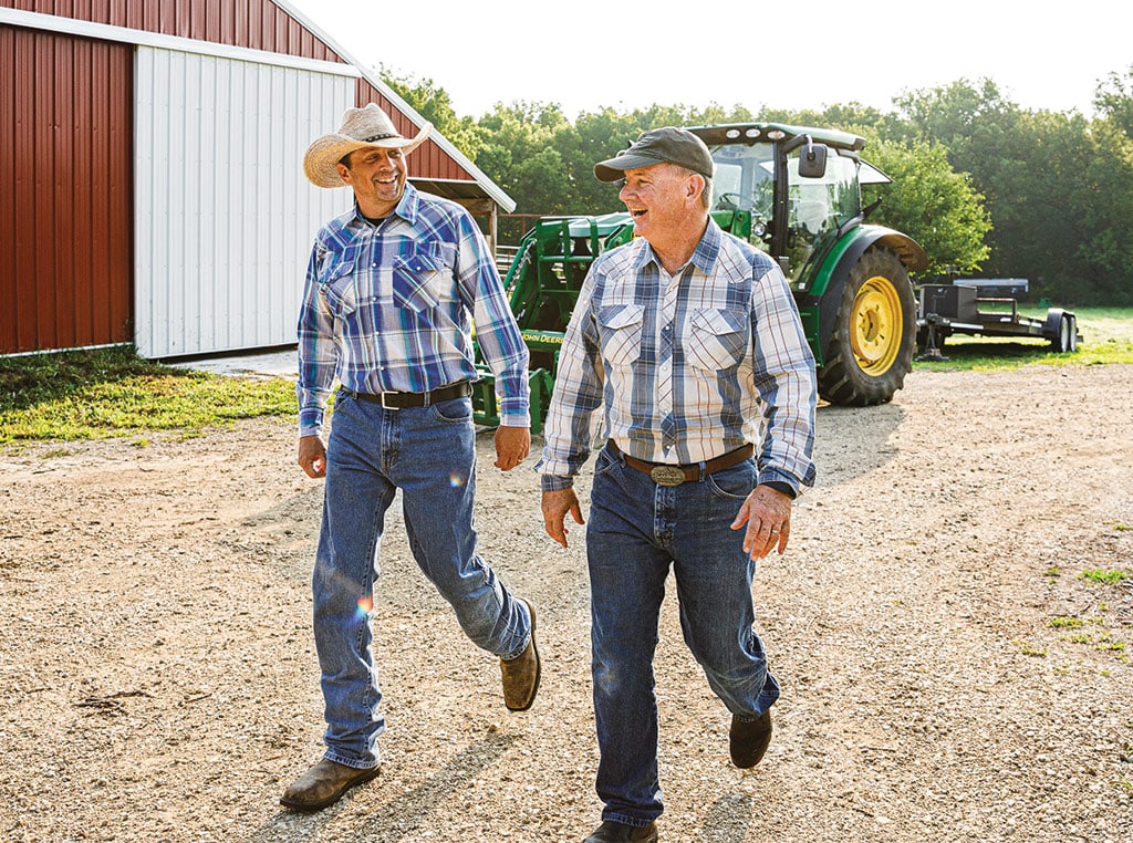 Two men walking in front of tractor