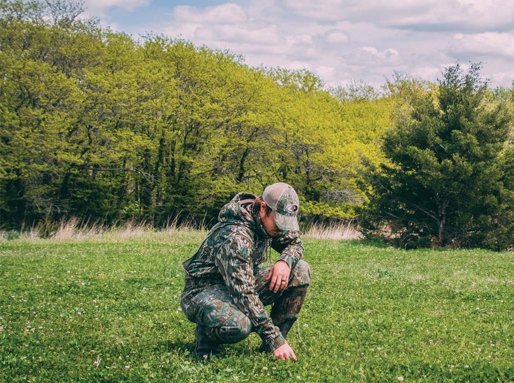 man in camo touching the ground