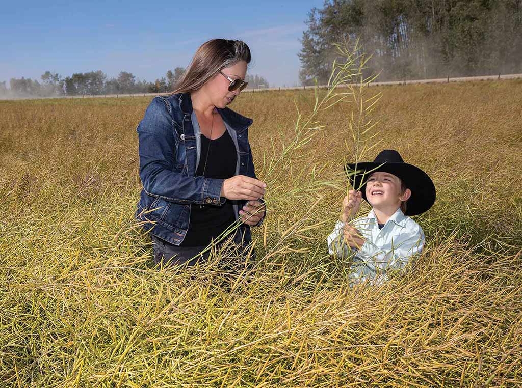 Mother and son in canola crop