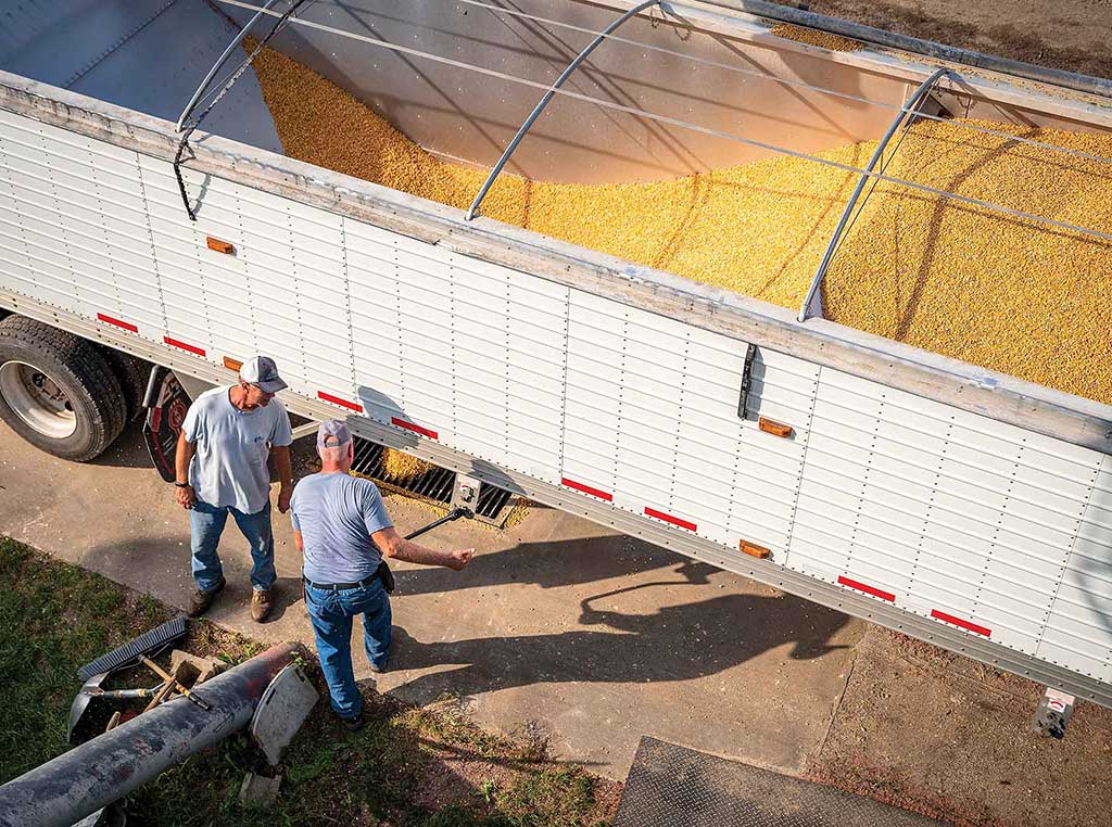 Men in front of grain tank