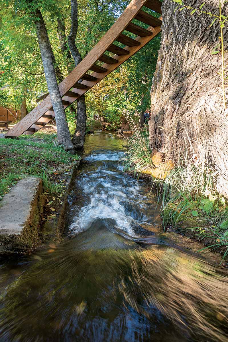 natural stream flowing under outdoor staircase