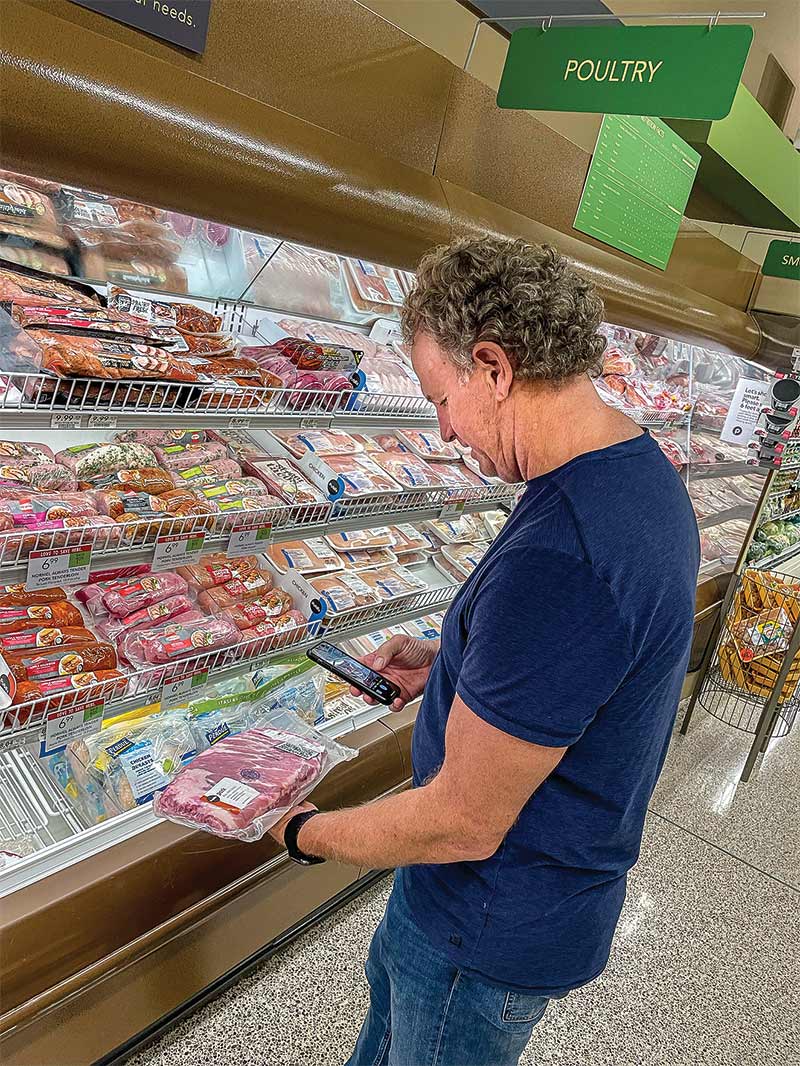 person looking at steak in grocery store