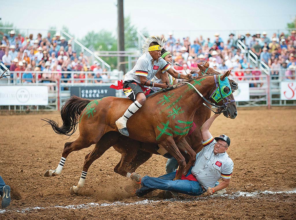 Man riding horse bareback while other man is run over