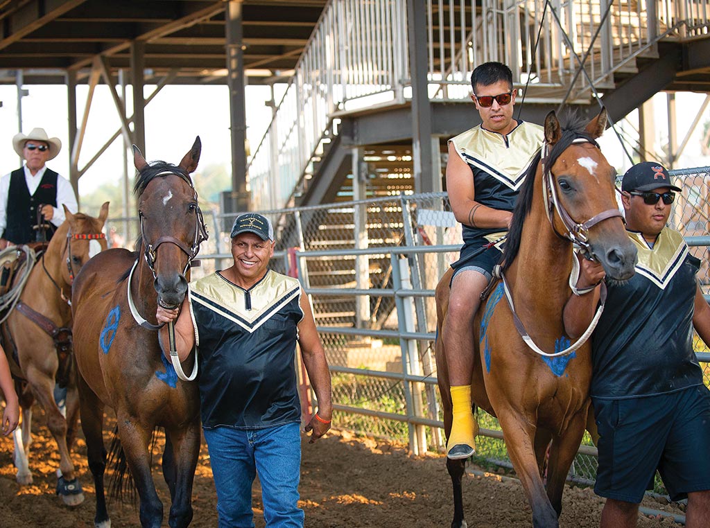 Man leading horse with rider