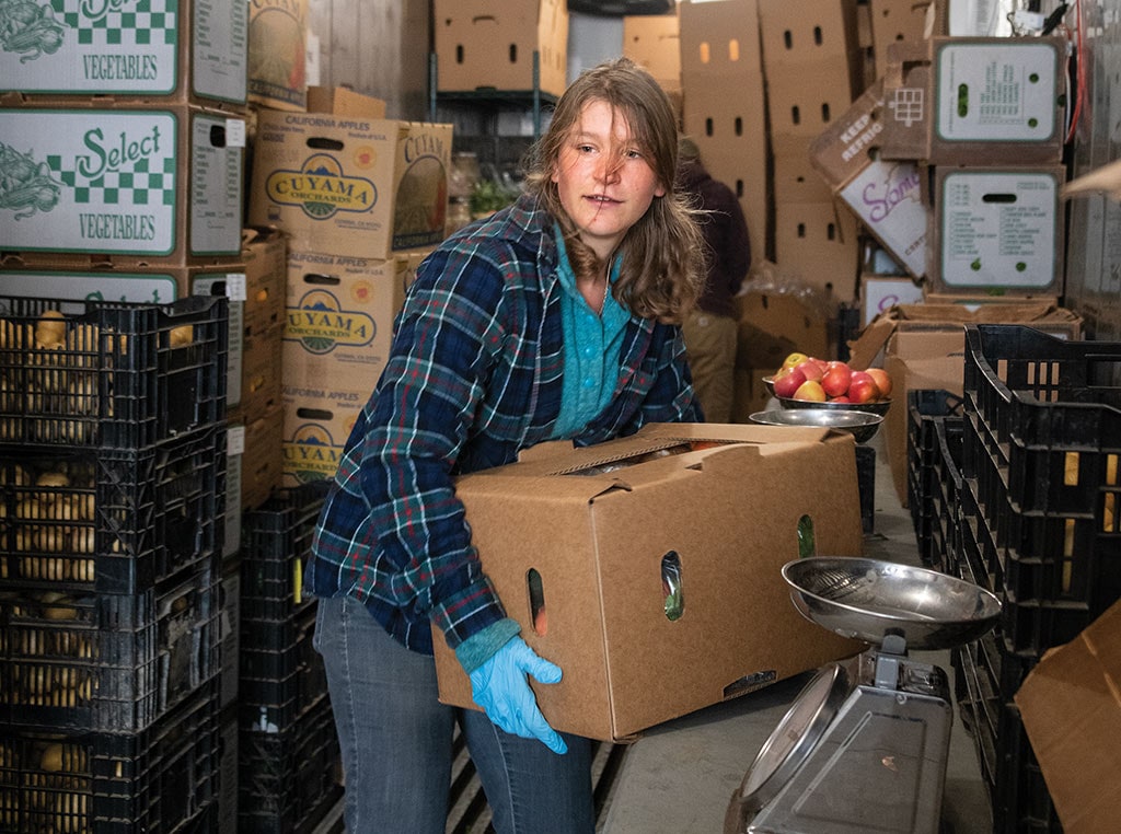 worker lifting box of produce