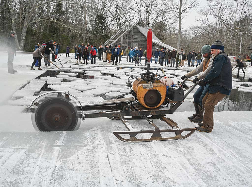 two men cutting ice with a power saw