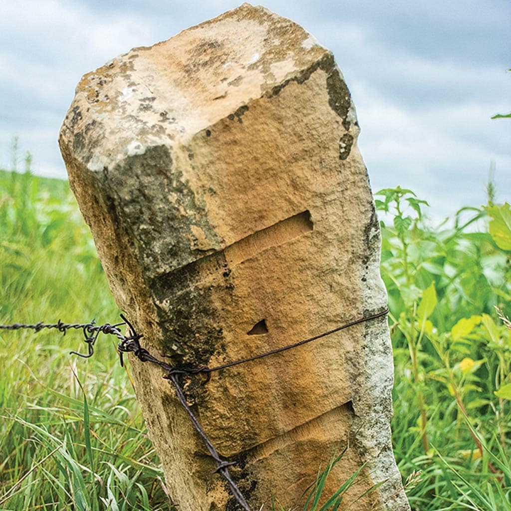 limestone fencepost with barbed wire
