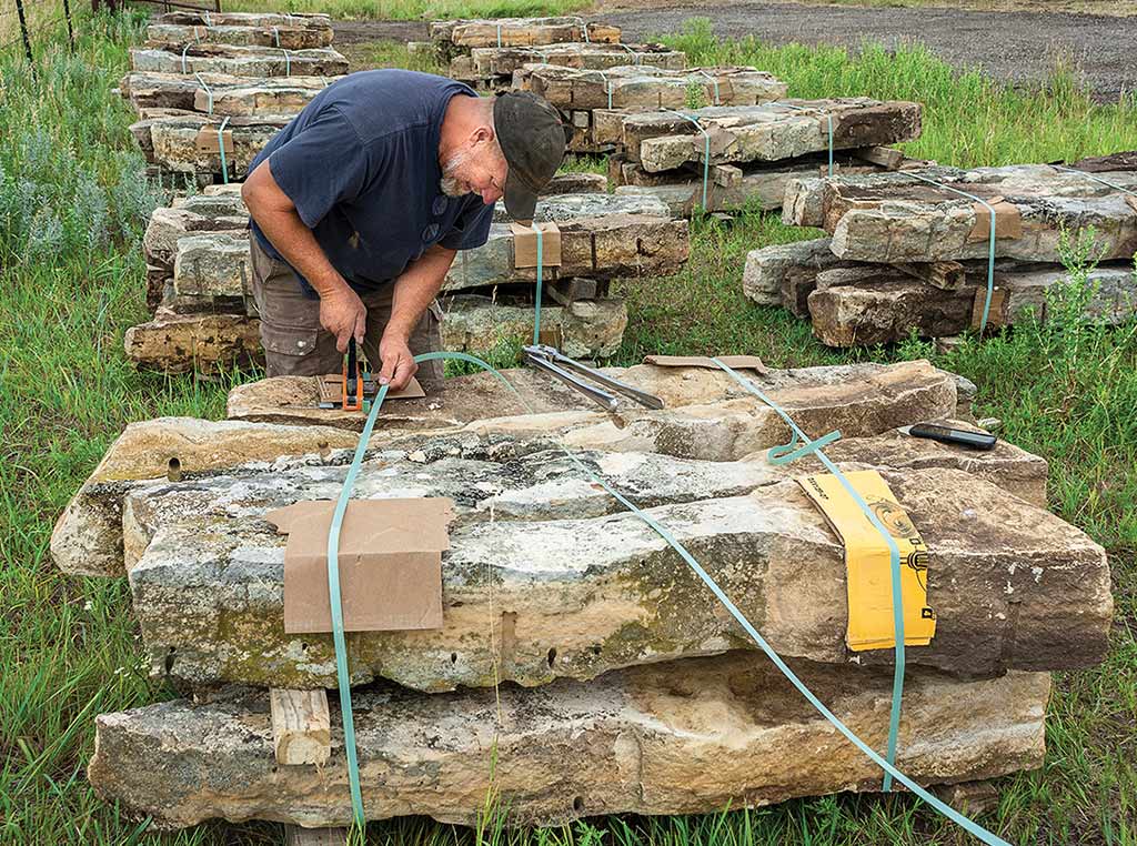 person tying limestone fenceposts into bundles