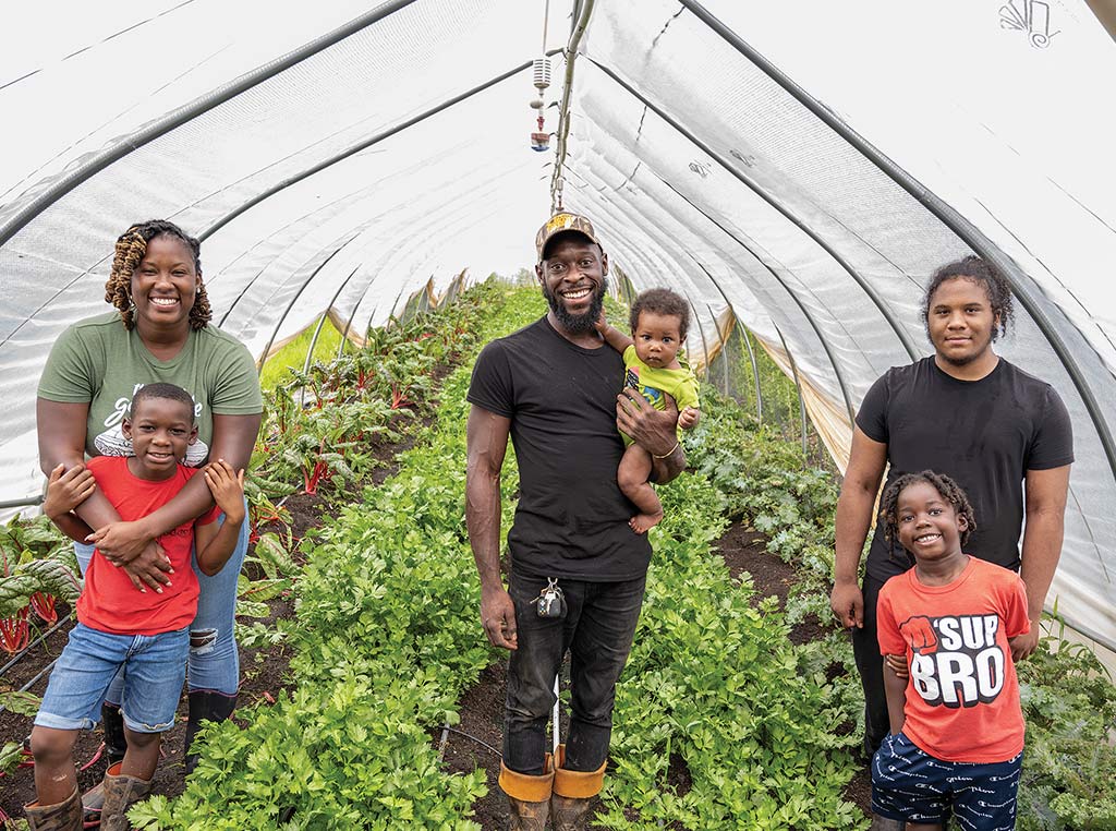 farming family smiling in tented garden
