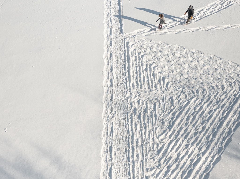 two people creating snow art