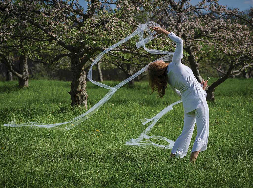 woman dancing among apple trees