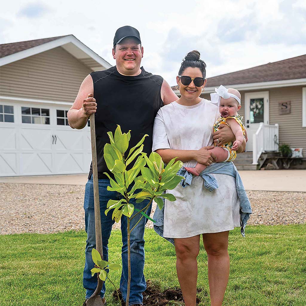 Stadel family standing with magnolia sapling