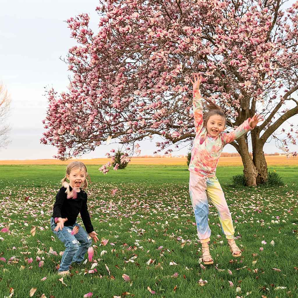 girls playing in magnolia petals