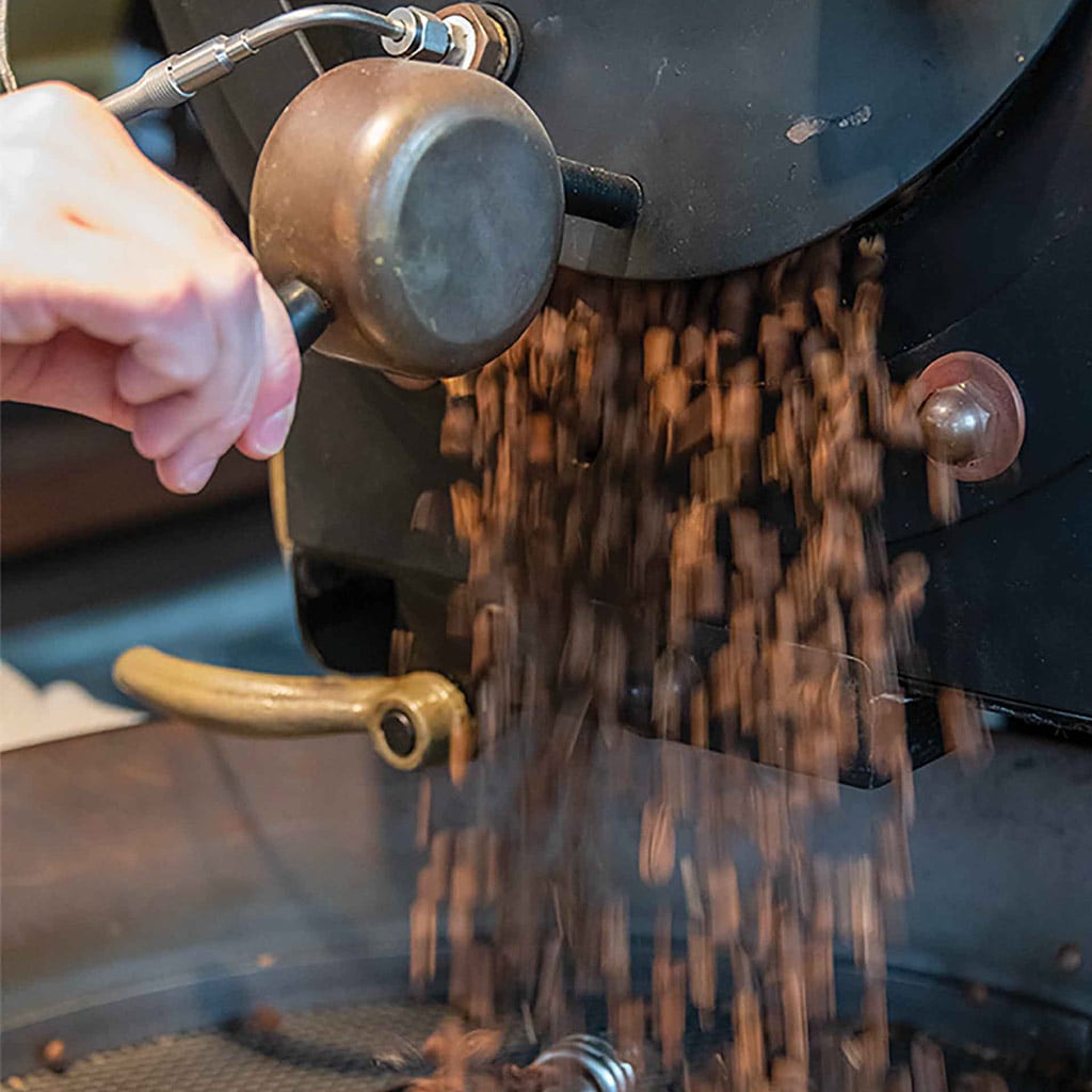 pouring coffee beans onto cooling grate
