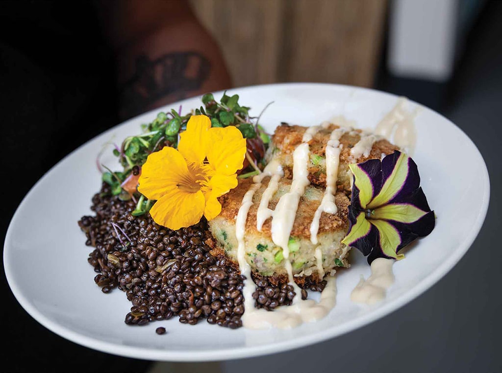 Dungeness crab cakes over lentils with flower garnishes