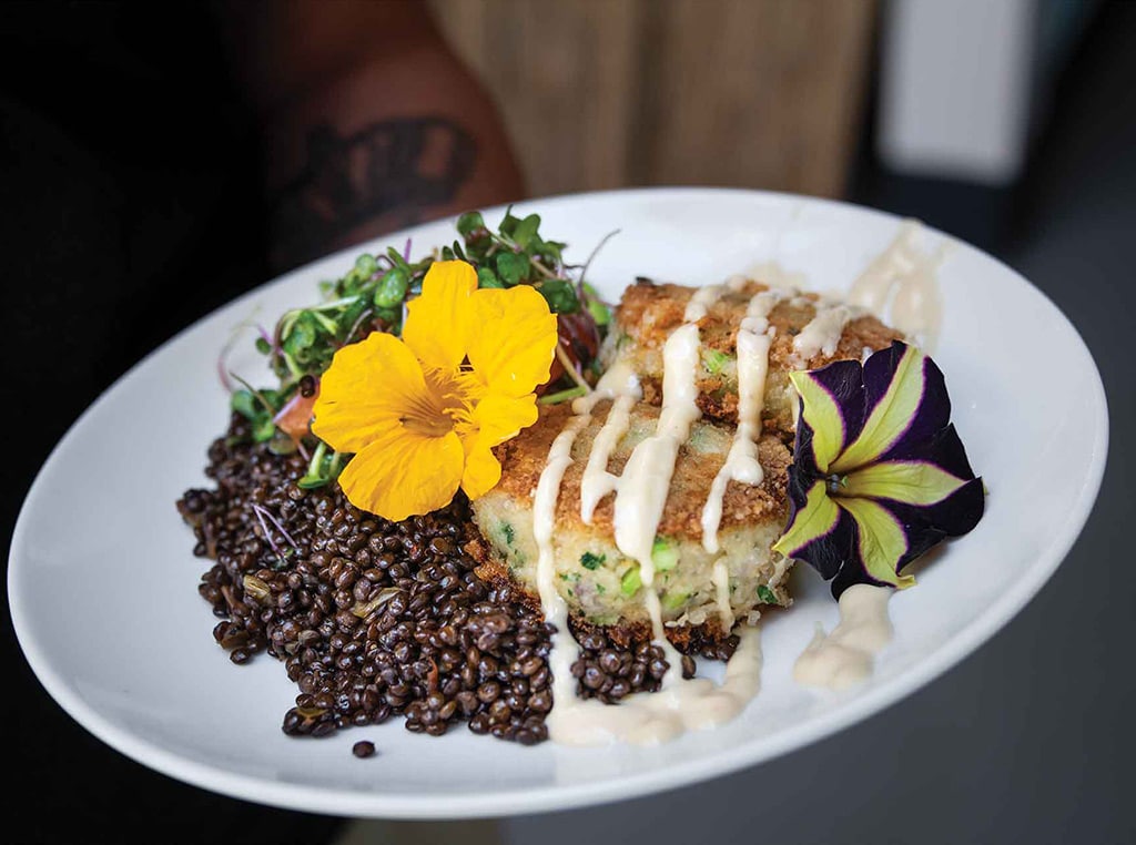 Dungeness crab cakes over lentils with flower garnishes