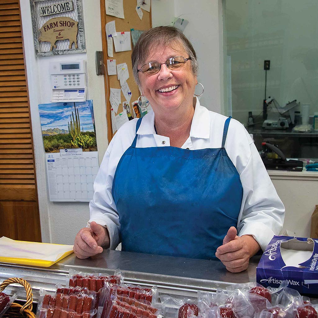 farm store owner presenting her sausage and jerky products
