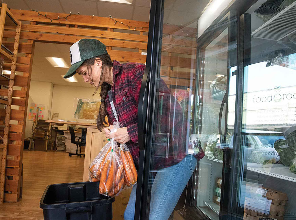 young woman stocking farm store shelves