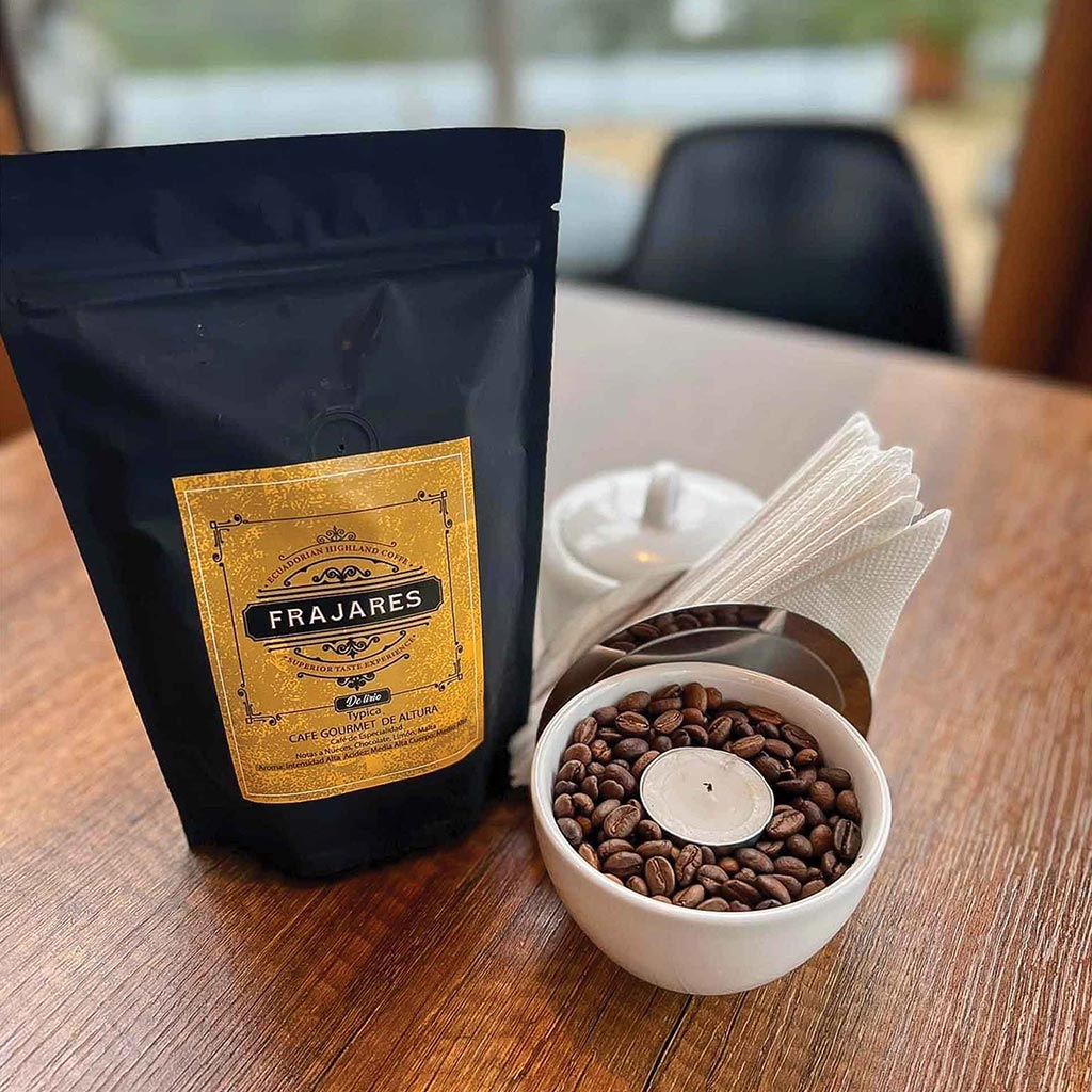 a bag of coffee beans next to a bowl of coffee beans topped with a votive candle