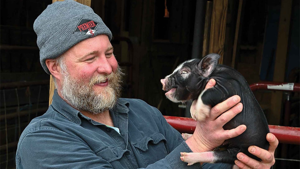 man holding piglet