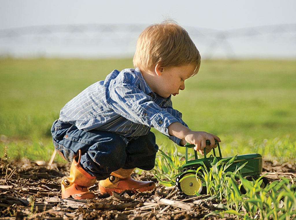 boy playing with Deere tractor