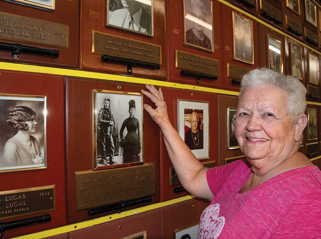 Woman smiling in front of photos