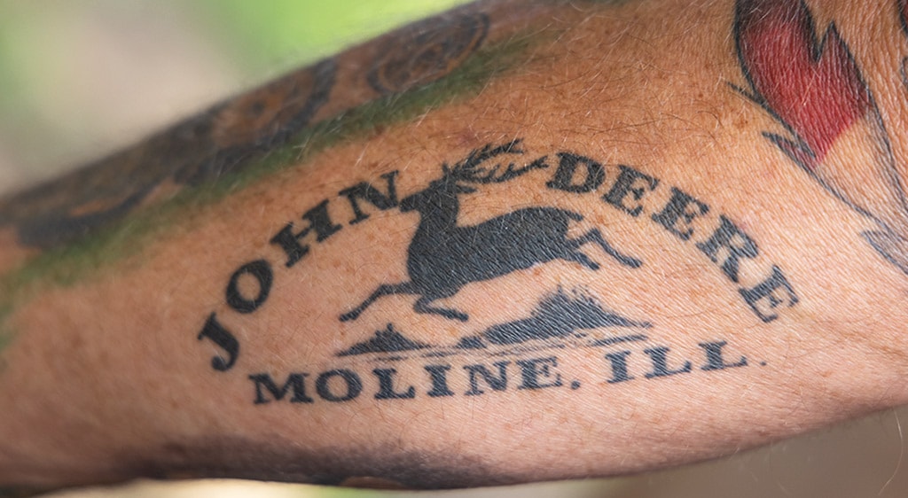 John Deere insignia tattoo on forearm