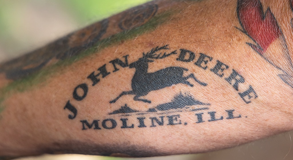 John Deere insignia tattoo on forearm