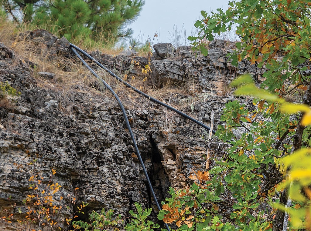 irrigation pipes hanging over rocky cliff