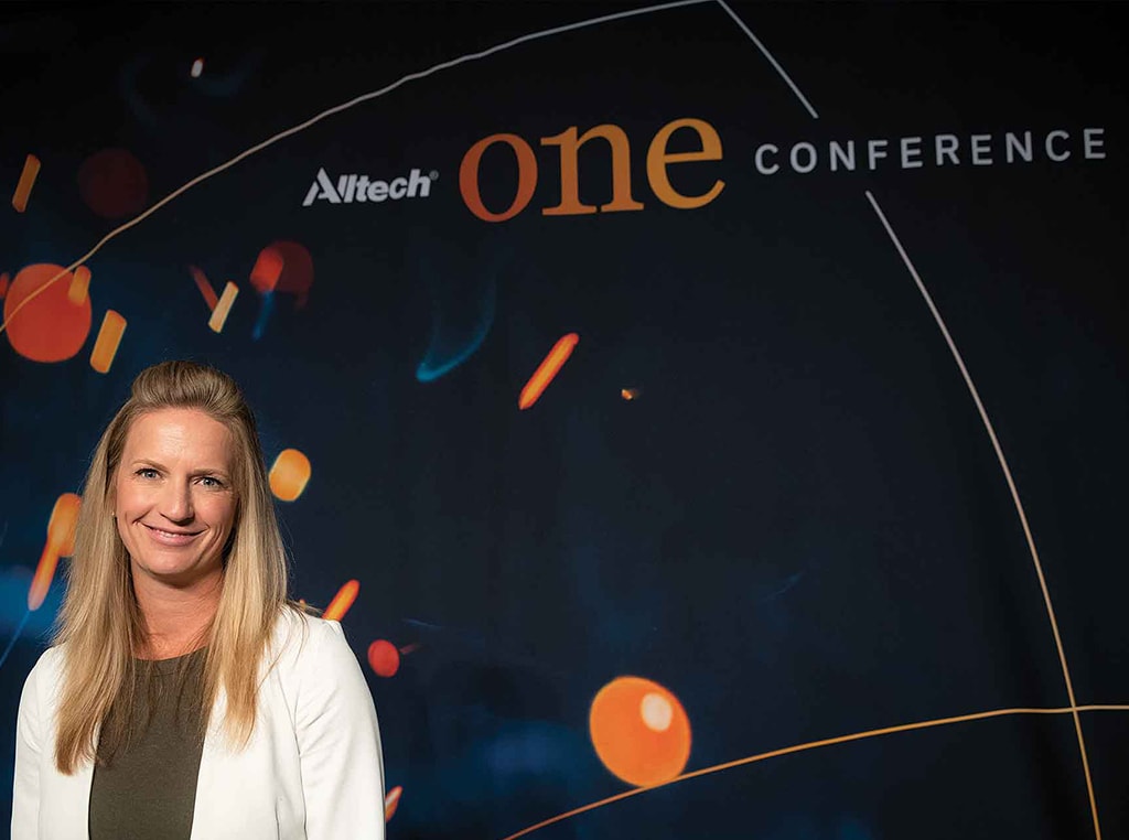 woman smiling in front of Alltech One conference background