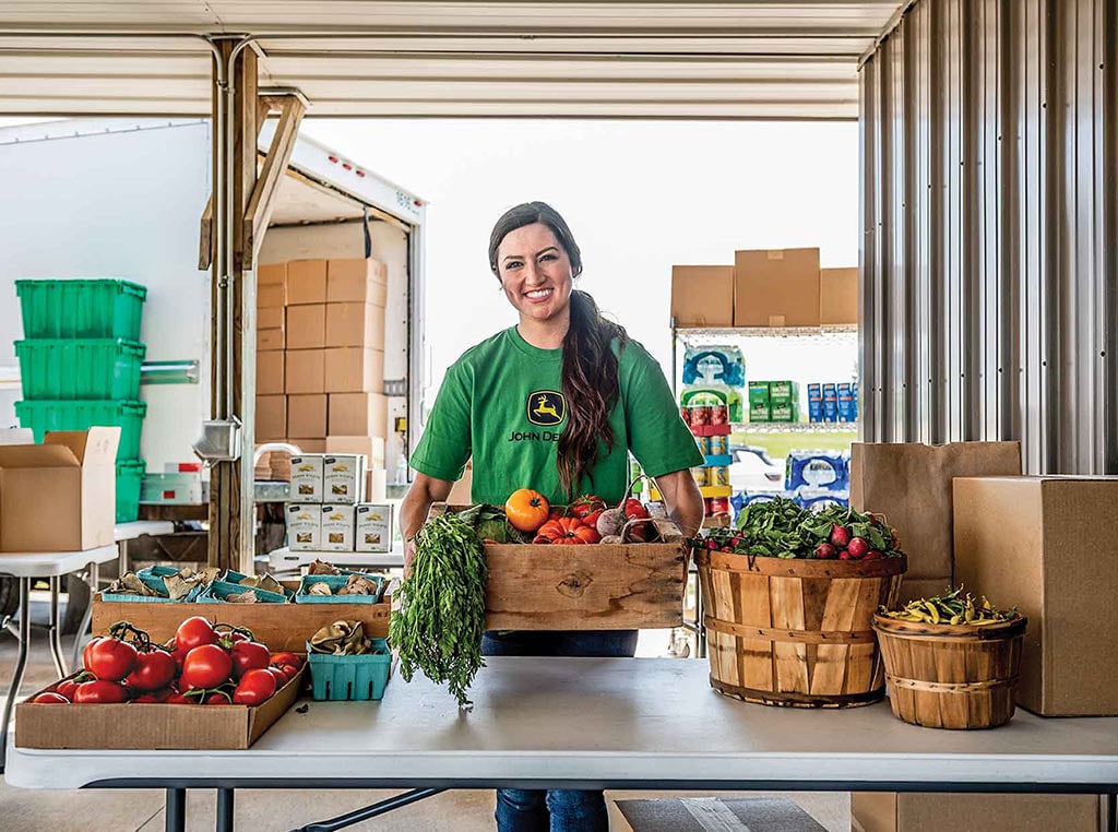 Deere employee loading crates of produce onto truck