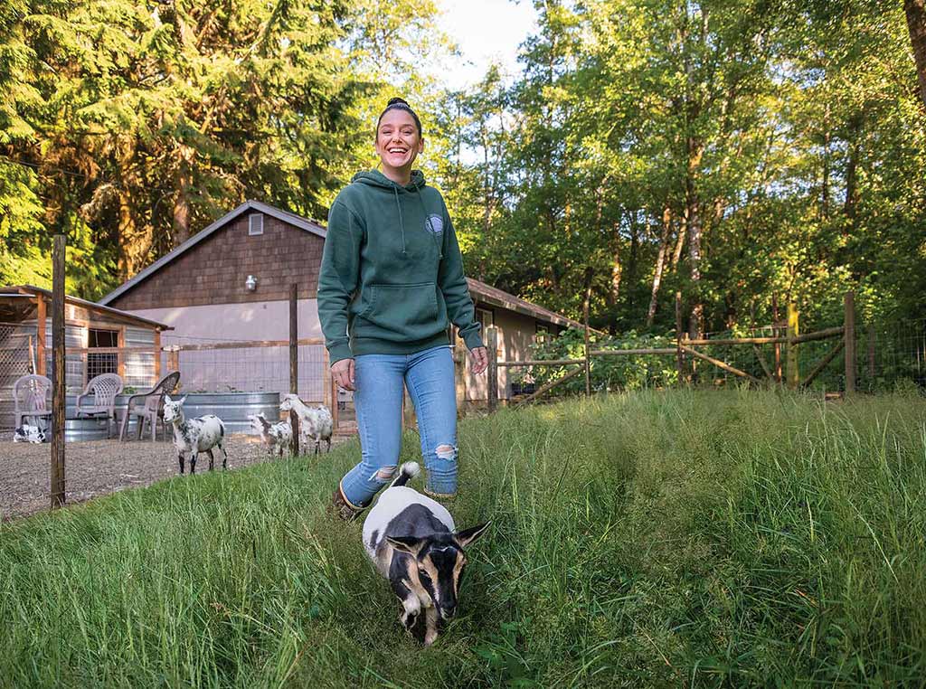 Daughter farmer Kuljus walking with goat kid