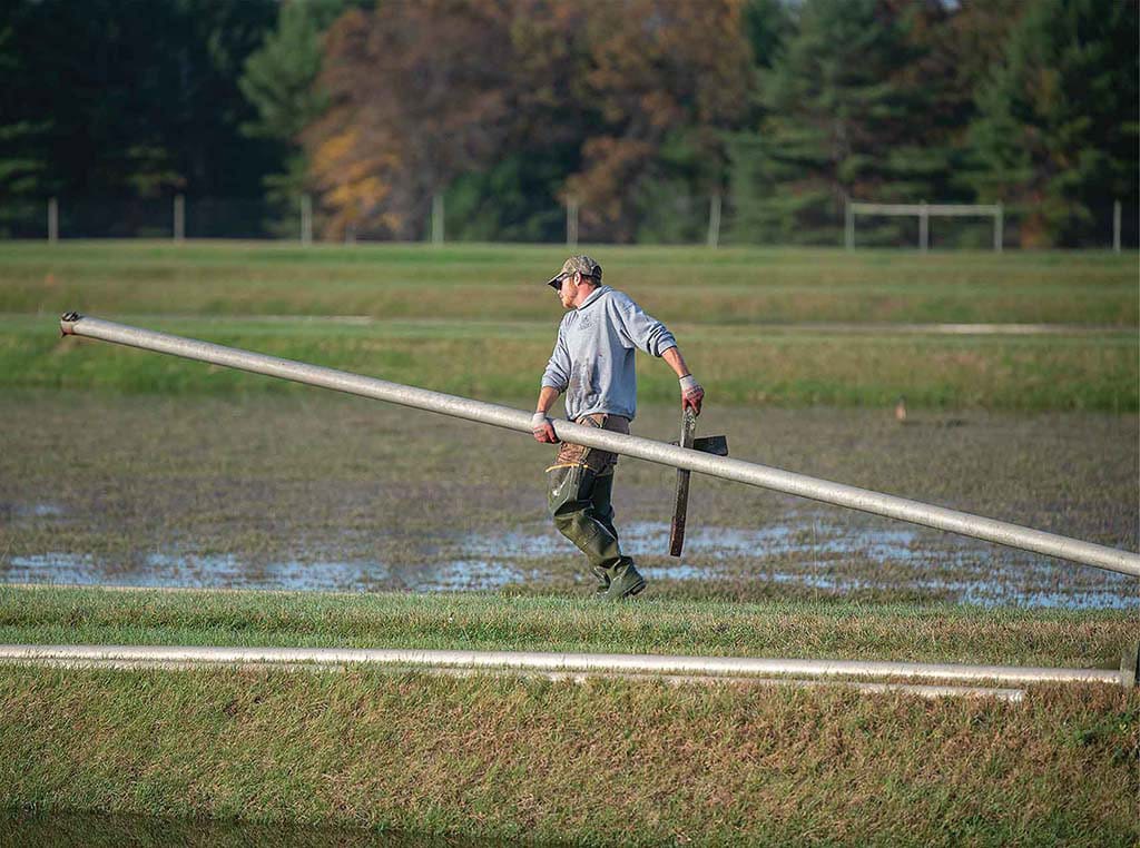 man irrigating cranberry farm