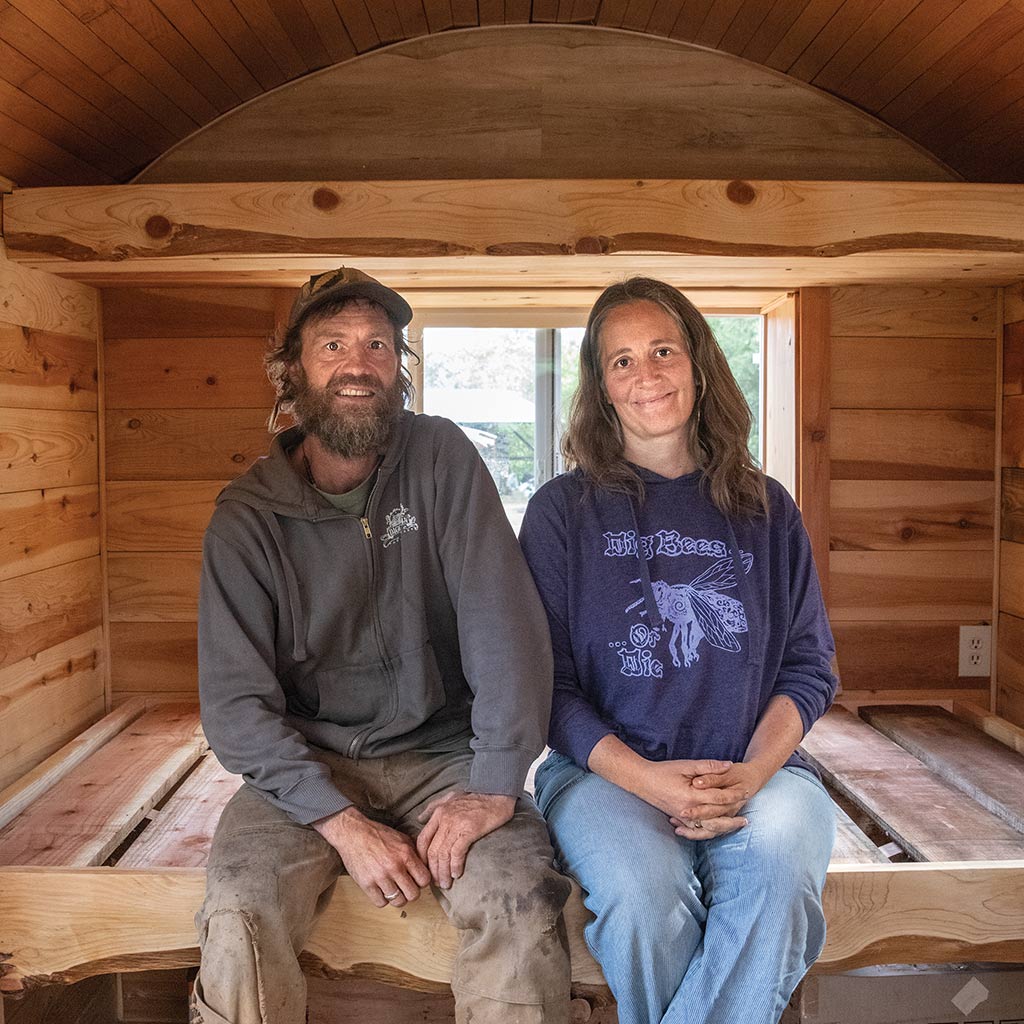 Beekeeper couple sitting in their wooden hive hut