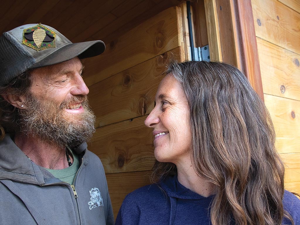 beekeeper couple smiling at each other in a doorway
