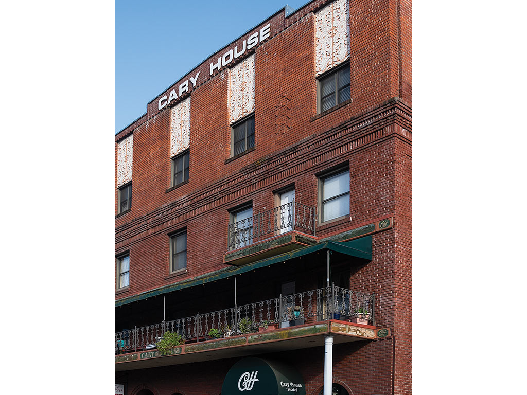  Brick building with wrought iron railed porches and the words Cary House at the top