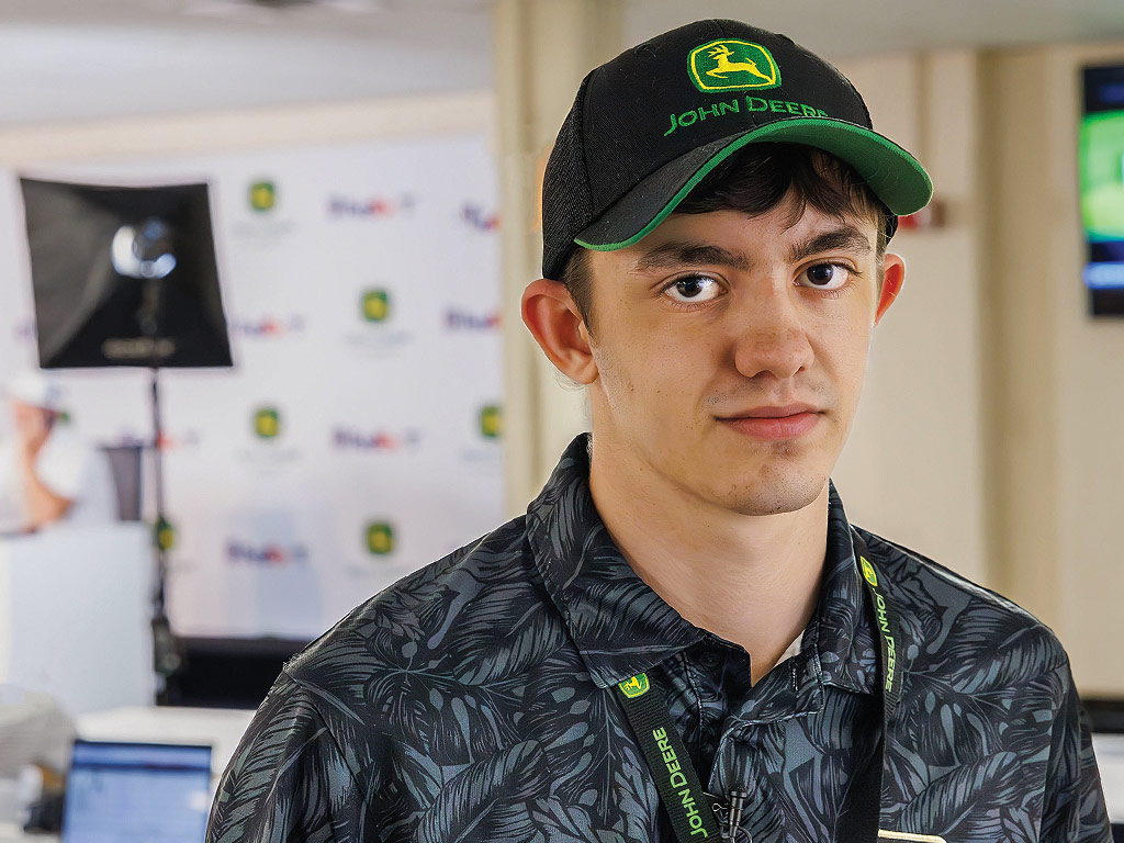 Closeup of young man with John Deere hat and collared shirt