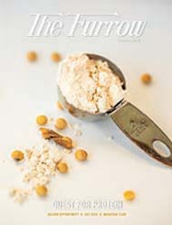 a measuring spoon full of soy flour with soy beans surrounding