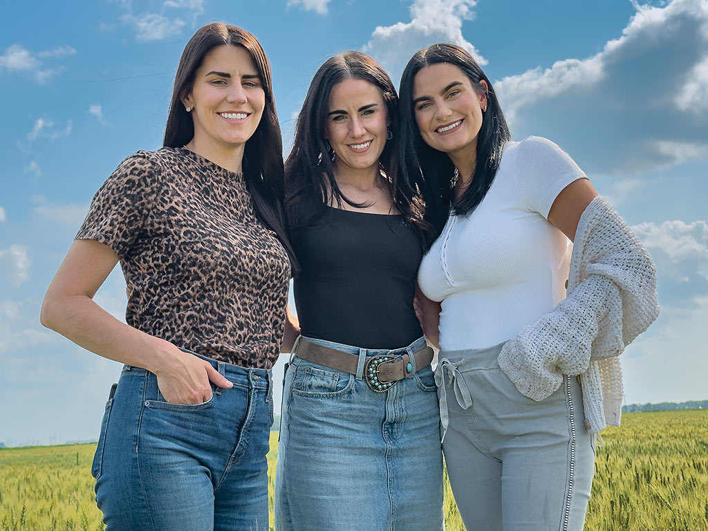  three women standing in a wheat field