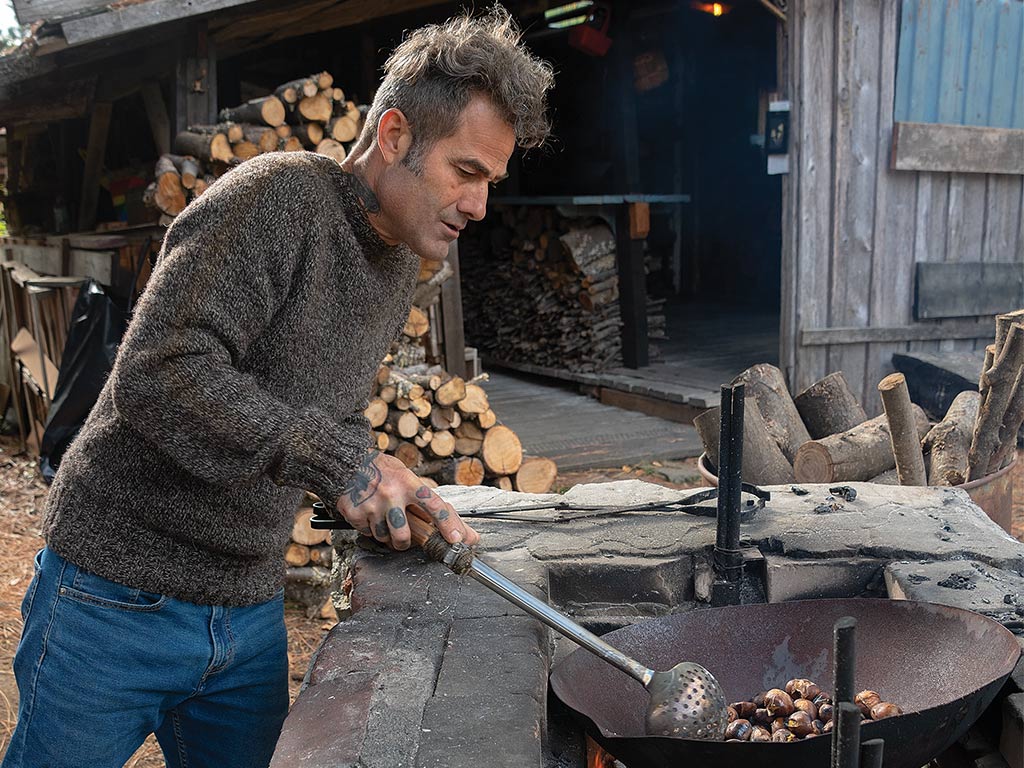 Man roasting chestnut outside his orchard