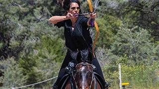 archer on horseback drawing an arrow on a bow