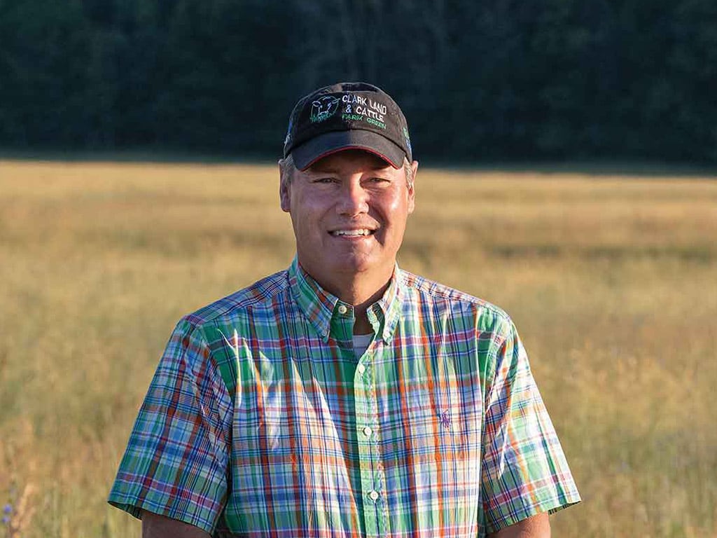 man standing in a field at dusk